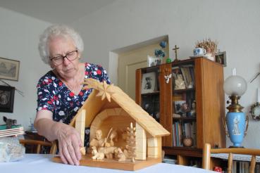 žena ukazuje vyřezávaný betlém