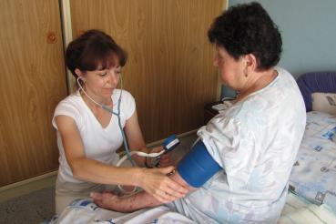 Zdravotní sestra měří ženě tlak.