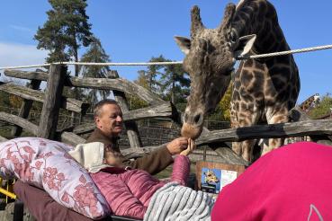 ležící pacientka si hladí žirafu