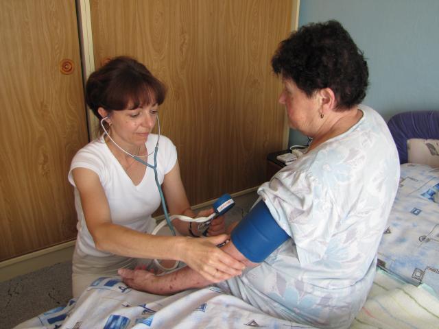 Zdravotní sestra měří ženě tlak.