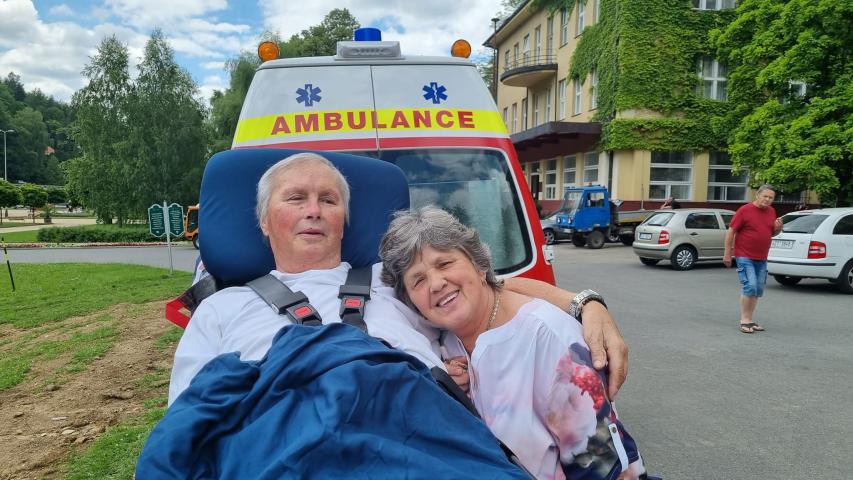 Pacient na lůžku objímá svoji družku před sanitkou v Luhačovicích.